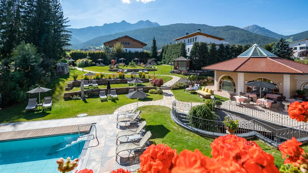 Garden with  pool and deck chairs of Mirabell Dolomites Hotel . Luxury . Ayurveda & Spa