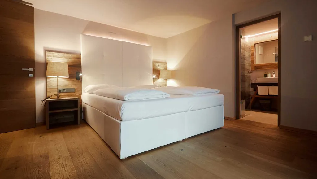 Room of Hotel Col Alto with wooden floor, white double bed