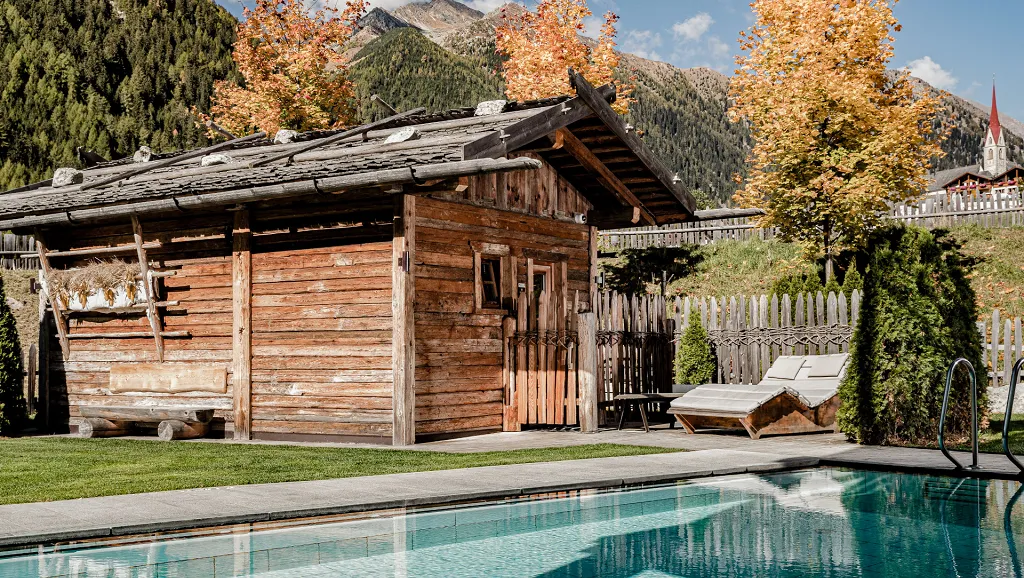 Outdoor pool with small wooden house in autumn of Hotel Masl